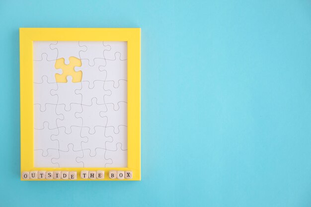 Missing white jigsaw puzzle yellow frame on blue background