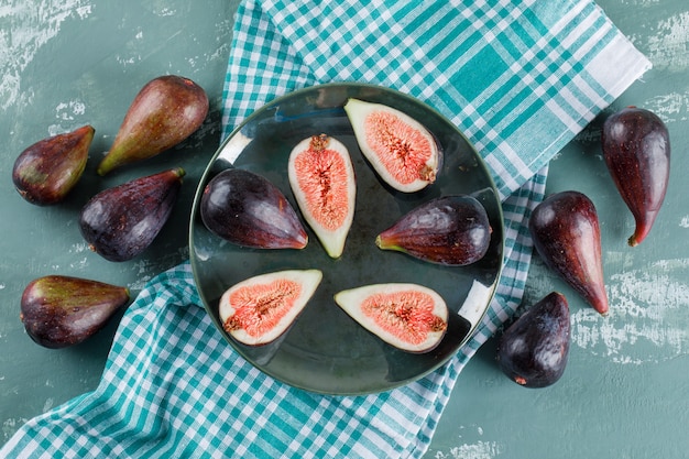 Foto gratuita missione di fichi e metà in una ciotola e nelle vicinanze su un panno da picnic e verde acqua. disteso.