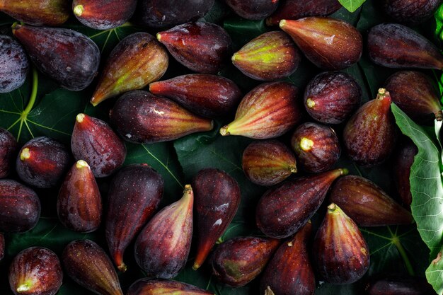 Mission figs with leaves background, top view.