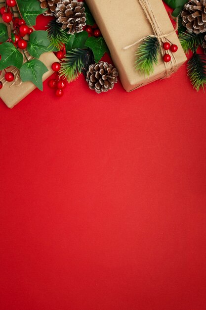 Free Photo mistletoe, pine cones and christmas gifts on red table