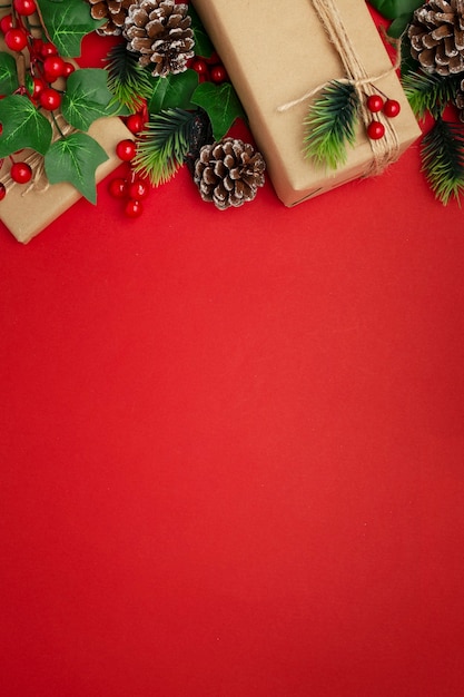 Mistletoe, pine cones and christmas gifts on red table