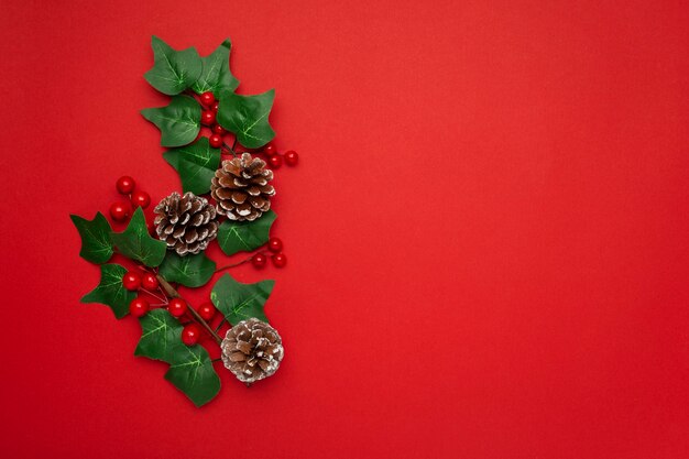 Mistletoe and pine cones on red table