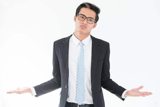 Misunderstanding Asian businessman shrugging arms