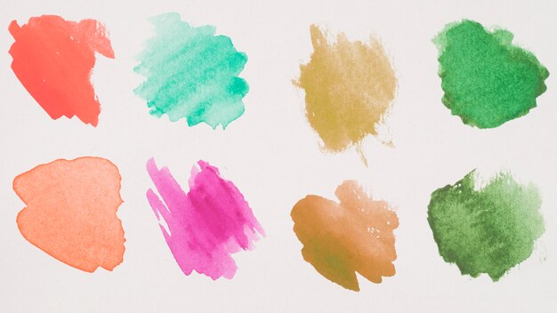 Mix of brown, green, aquamarine, red and pink paints on white paper