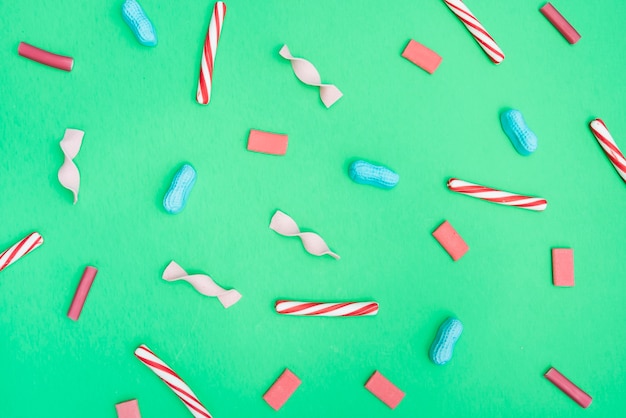 Mix of candies spread on green table 