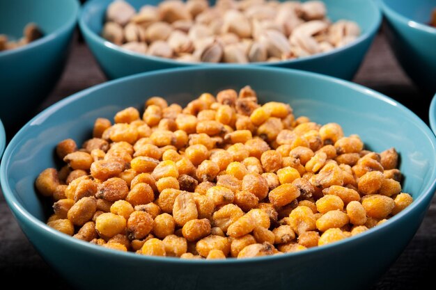 Mix of delicious different type of nuts in bowls on wooden background