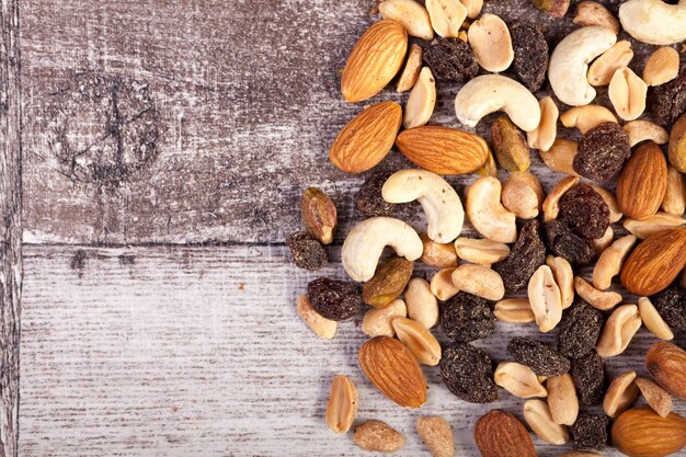 Mix of delicious healthy raw nuts on wooden background in studio photo. Healthy organic snack