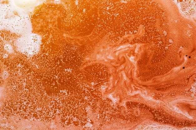 泡とオレンジの水の混合