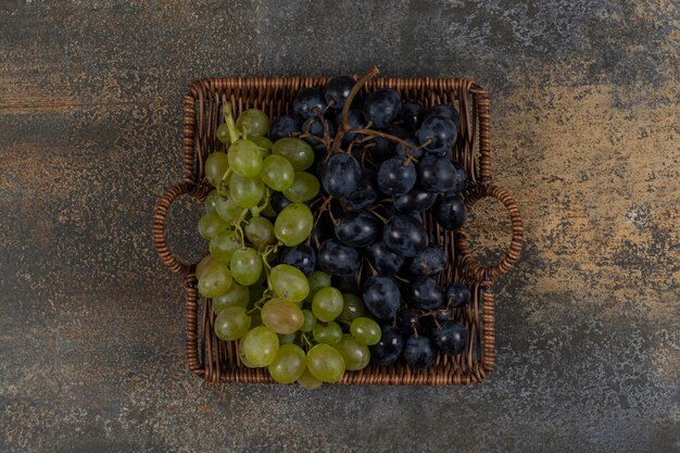 Mix fresh grapes in wooden basket.