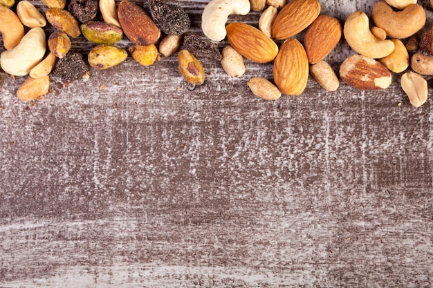 Mix of healthy raw nuts on wooden background with copyspace available on wooden background in studio photo. Healthy organic snack