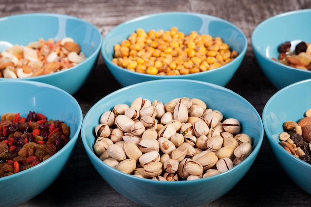 Mix of nuts in bowls on wooden background