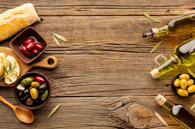 Mix of olives in bowls olive oil bottles and bread with copy space