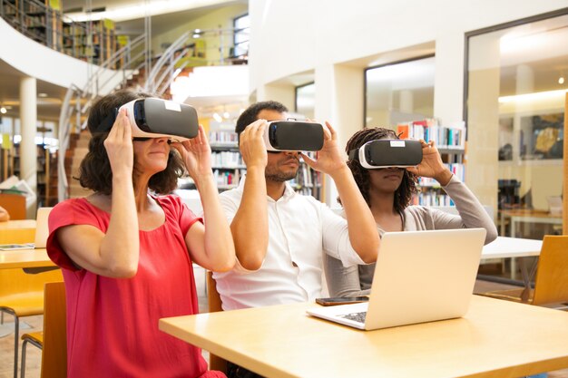 Mix raced team of adult students wearing VR goggles