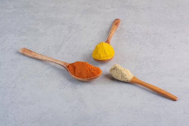 Mix of spices in woode spoon on concrete background. 