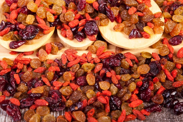 Mix of sweet dried fruits in wooden spoon on wooden background in studio photo. Healthy lifestyle