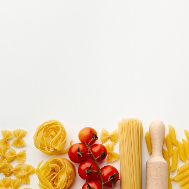 Mix of uncooked pasta and cherry tomatoes with copy space