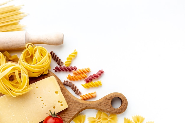 Free photo mix of uncooked pasta and hard cheese with copy space