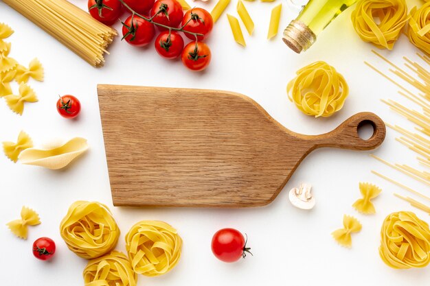 Mix of uncooked pasta tomatoes and cutting board