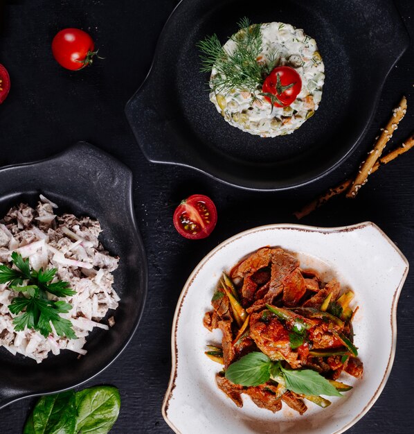 Mixed foods in white and black pans.