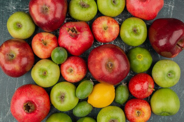 Mixed fresh fruits scattered on marble surface.