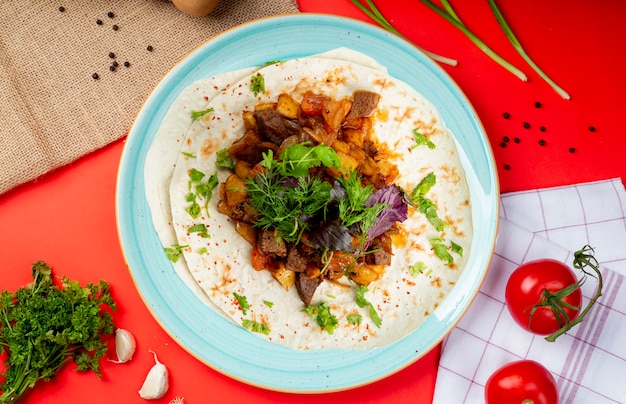 Mixed fried meat and vegetables on lavash