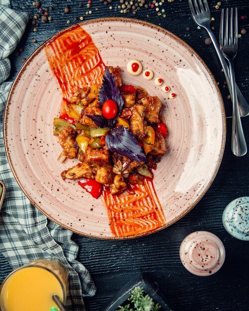 バジルをトッピングした揚げ野菜と肉のミックス