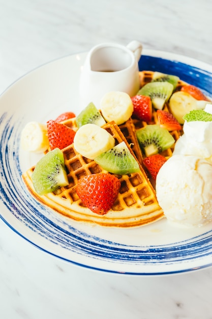 Mixed fruit on top of pancake and ice cream