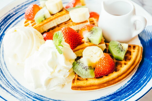 Mixed fruit on top of pancake and ice cream