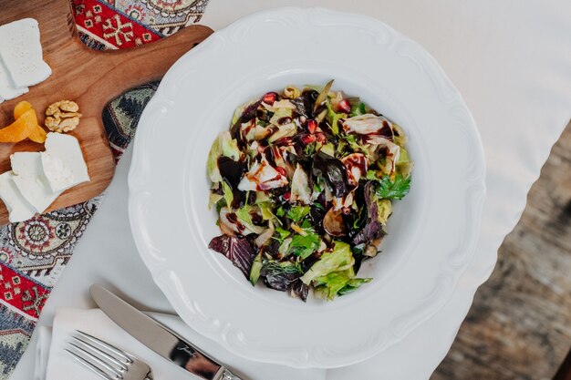 Mixed green vegetables salad with balsamic vinegar inside white plate.