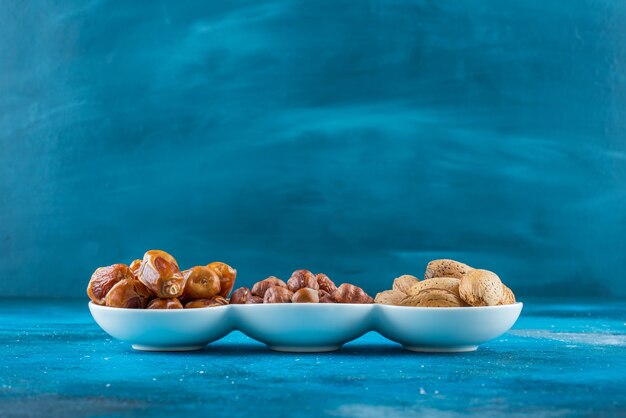 Смесь орехов в миске на синей поверхности