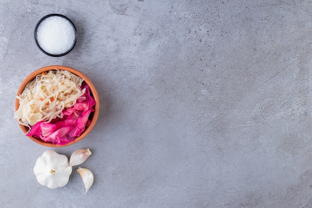 Mixed pickled vegetables placed on stone table.