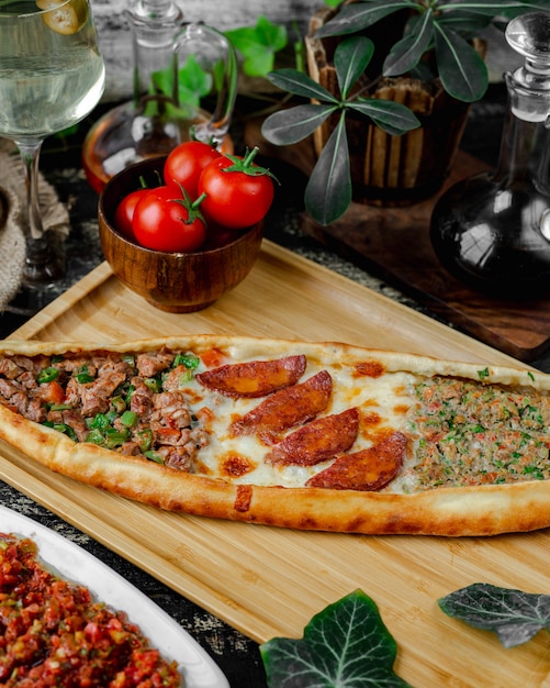 Free photo mixed pide filled with sausage, cheese and meat