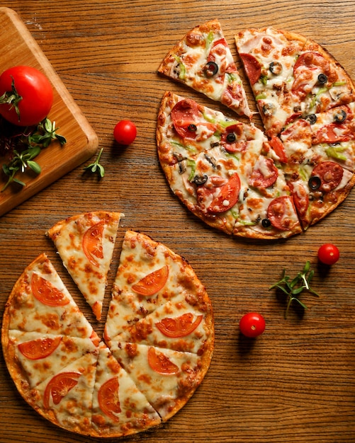 Free photo mixed pizza with sausage and pizza with cheese and tomatoes