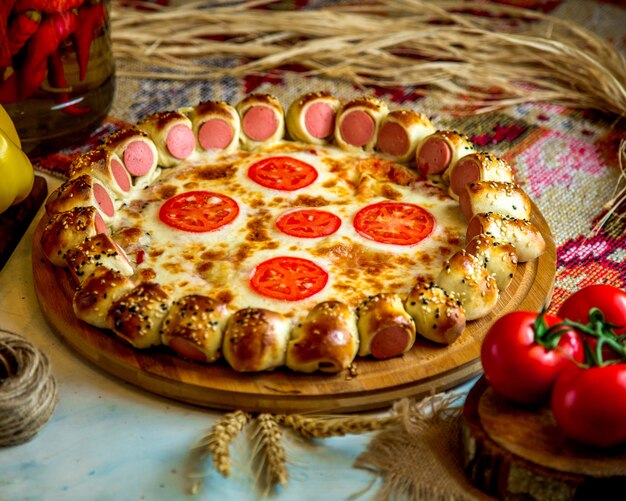 Mixed pizza with sausages and tomato