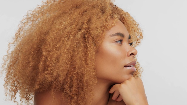 Free photo mixed race black blonde model with curly hair in profile turned to the right