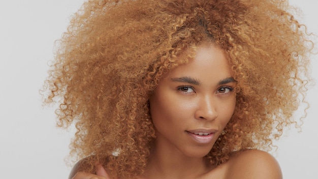 Mixed race black blonde model with curly hair watching to the camera