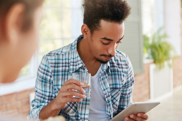 Mixed race male student has deadline for preparation on final exam, searches internet to find answers