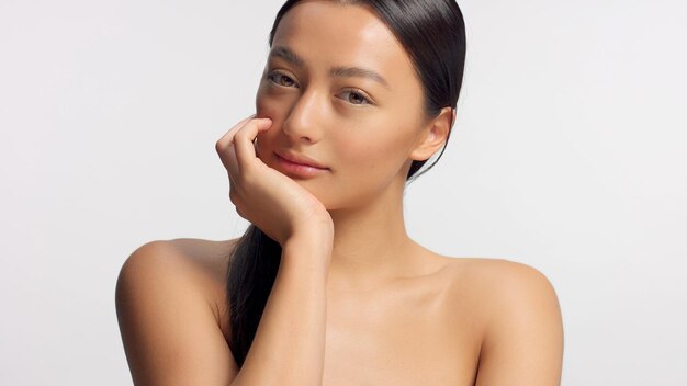 Mixed race model with head rest on hand watching to the camera Ideal glowy skin head and shoulders crop