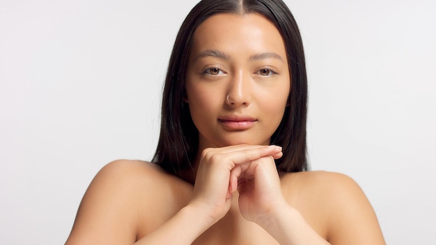 Free photo mixed race model with head rest on hands watching to the camera ideal glowy skin head and shoulders crop symmetrical shoot