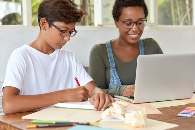 Mixed race teenagers study school course from home, do exercises