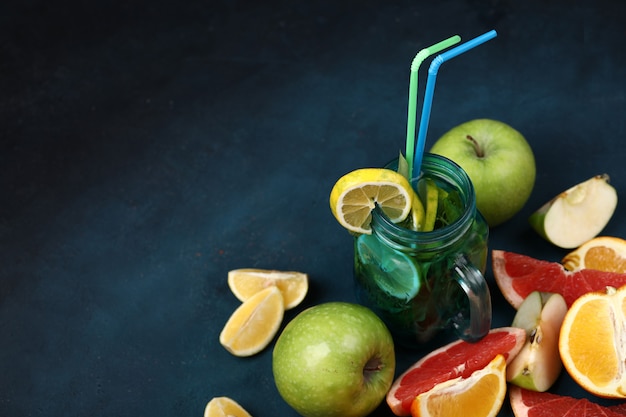 Mixed sliced fruits and a blue jar of mojito