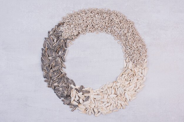 Mixed sunflower seeds on white surface.