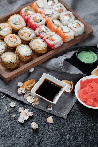 Sushi misto posto su una tavola di legno con salsa di soia da parte.