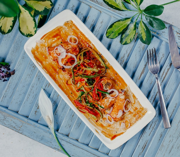 Mixed vegetable salad in tomato sauce inside white plate.