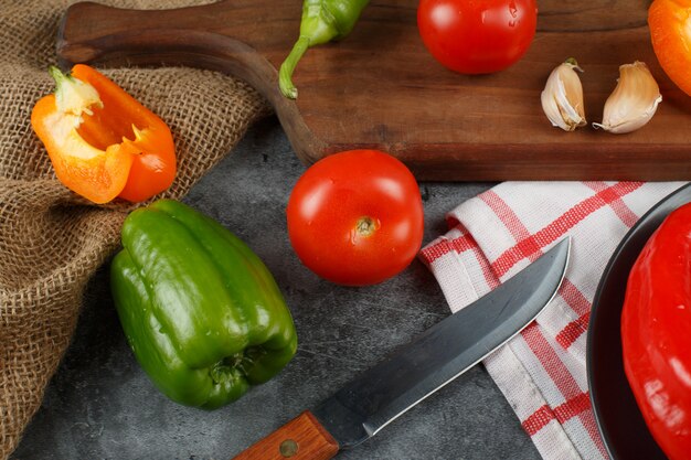 Mixed vegetables and a knife on a checked towel. Top view.