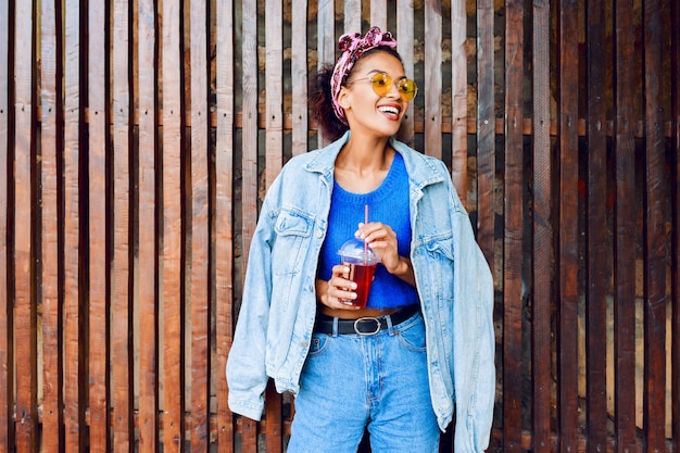 Mixed woman with hairs having fun , smiling , posing outdoor on wood urban wall.