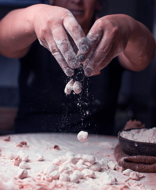 Mixing ready turkish manti pieces with flour.