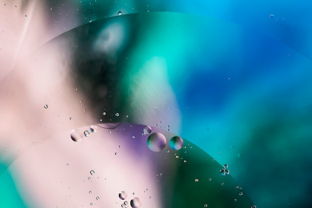 Mixing water and oil on a coloured liquid abstract background 