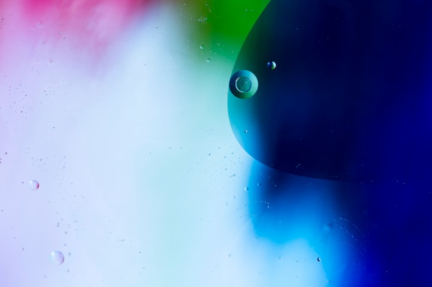 Mixing water and oil on a coloured liquid abstract background 