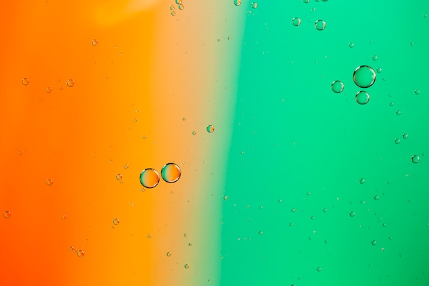 Mixing water and oil on a coloured liquid abstract background 